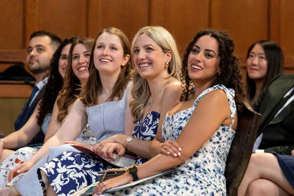 Row of seated graduates listening to speech