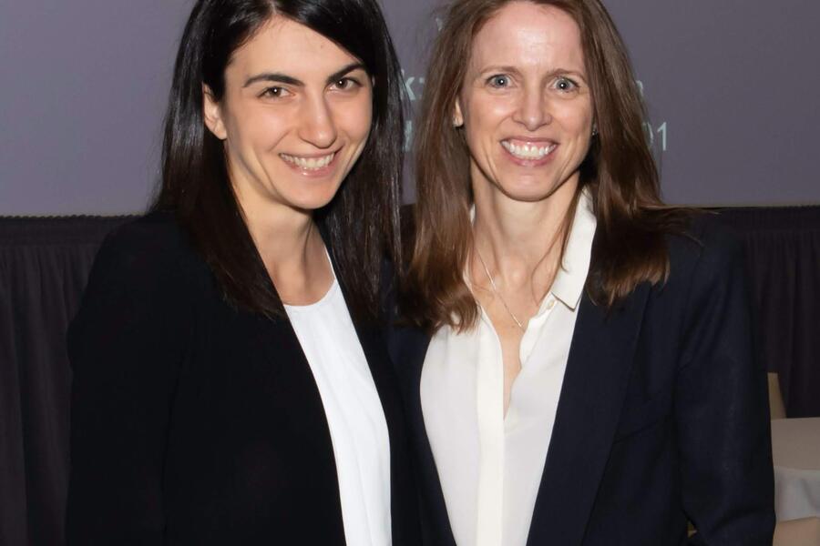 Trainee and faculty member smiling at camera at conference