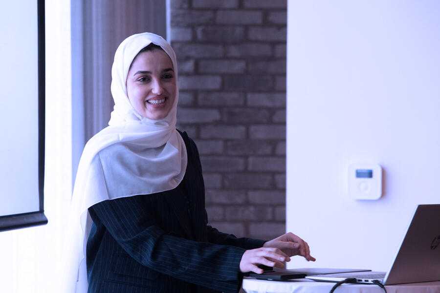 Standing woman on laptop, presenting