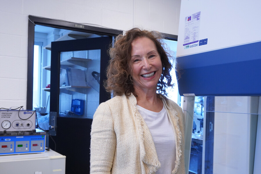 Dr. Heather Shapiro smiles as she poses in front of the Clinical Embryology Skills Development Lab at the University of Toronto
