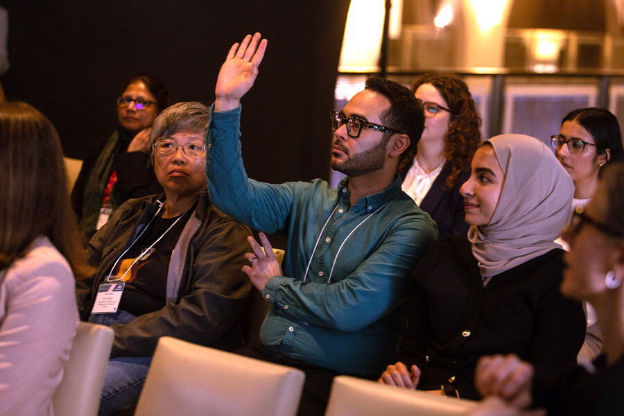 Man with hand raised to ask a question