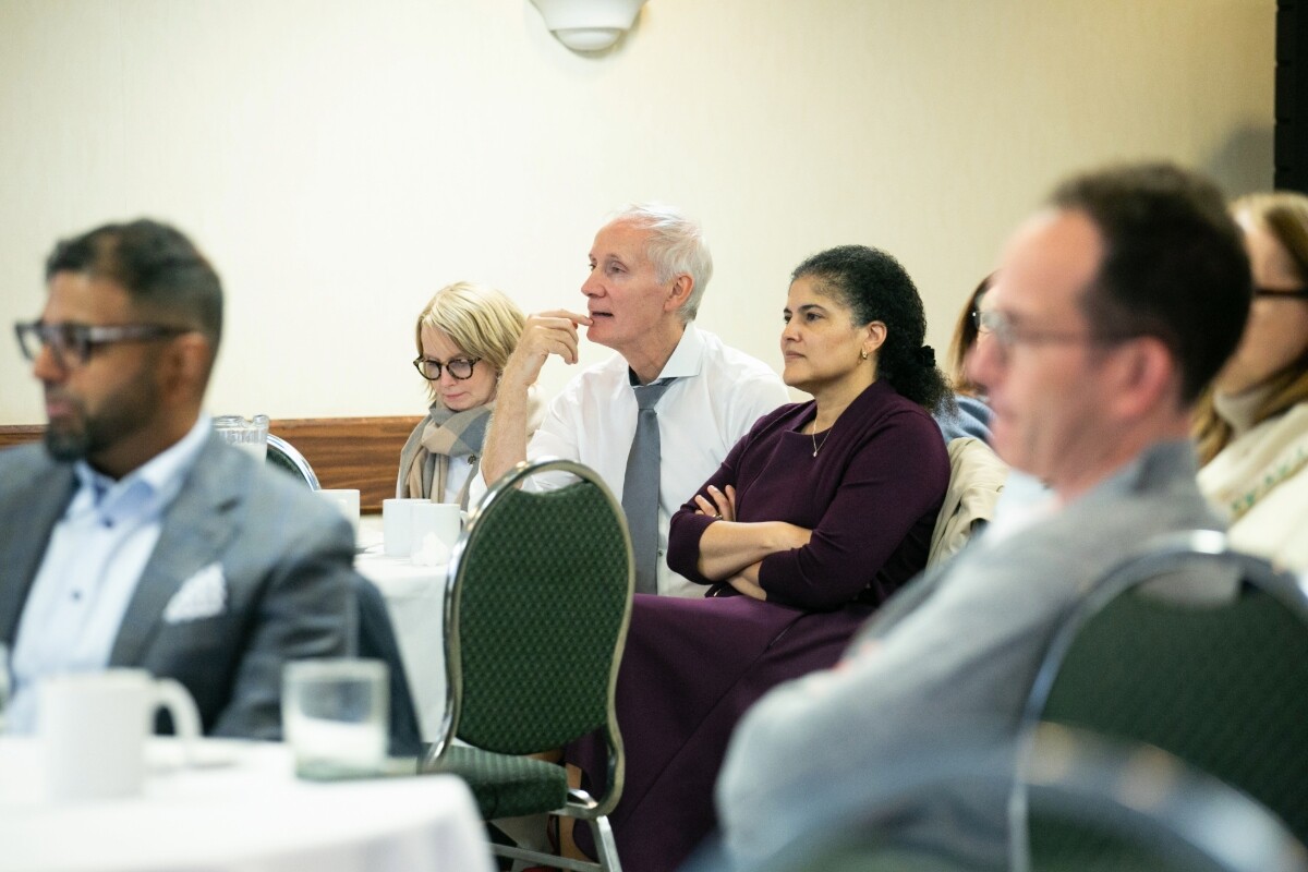 Faculty seated and listening to a presentation