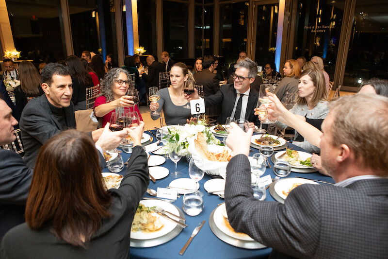 A table of guests raise their glass for a toast